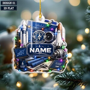 May include: A flat, decorative ornament featuring aerospace engineering graphics including rockets, a space shuttle, blueprints, a laptop, a mug labeled 'AEROSPACE ENGINEER', and a notebook labeled 'FLIGHT PLANS'. The center displays 'NAME' in bold text.