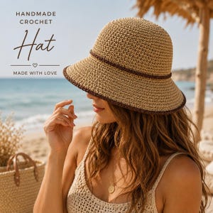 Puede incluir: Un sombrero de ganchillo hecho a mano en color beige con una banda marrón oscuro alrededor de la copa y un borde a juego en marrón oscuro. El texto en la imagen dice: HANDMADE CROCHET Hat MADE WITH LOVE.
