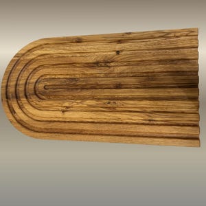 May include: A wooden cutting board with a unique design. The board is rectangular with a rounded end and features a series of concentric grooves. The wood has a warm, natural tone with visible grain, and the board measures approximately 18 inches long.