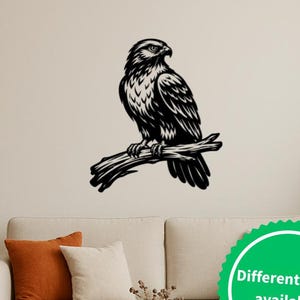 Könnte beinhalten: Schwarze Metall-Wandkunst, die einen auf einem Ast sitzenden Falken darstellt. Der Falke ist mit komplizierten Federstrukturen versehen. Der Text "Different sizes available" befindet sich in einem grünen Kreis.