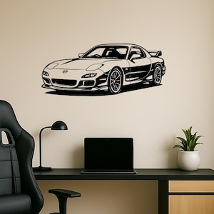 Puede incluir: Arte mural en blanco y negro de un coche deportivo. El coche es un cupé con alerón y ruedas detalladas. El arte está montado en una pared beige sobre un escritorio negro con una silla negra, un portátil, una lámpara de escritorio y una planta en maceta.