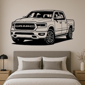Peut inclure: Illustration en noir et blanc d'un pick-up RAM. L'image met en évidence la calandre, les phares et les roues du camion. Le mot "RAM" est visible à l'avant du véhicule.