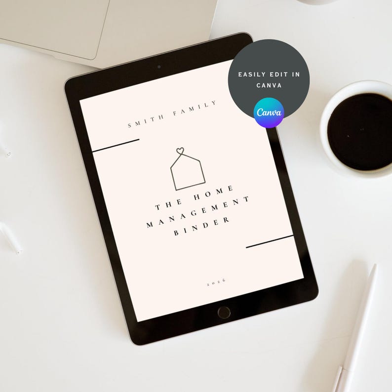 May include: A black tablet displaying a home management binder design. The design includes the text "Smith Family" and "The Home Management Binder" with a house icon. A coffee cup and pen are visible.