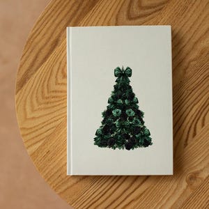 Pode incluir: Um caderno branco com um desenho de &aacute;rvore de Natal verde. A &aacute;rvore &eacute; feita de rosas e la&ccedil;os verdes. O caderno est&aacute; numa mesa de madeira.