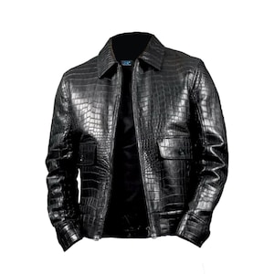 Może przedstawiać: Czarna skórzana kurtka o fakturze skóry krokodyla. Kurtka ma kołnierz, zapięcie na zamek błyskawiczny i dwie przednie kieszenie. Projekt obejmuje wzór o fakturze na całej odzieży.