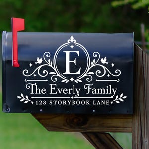 Könnte beinhalten: Schwarzer Briefkasten mit roter Fahne, mit weißem dekorativem Text. Der Text enthält den Familiennamen "The Everly Family", den Buchstaben "E" in einem kreisförmigen Design und die Adresse "123 Storybook Lane".