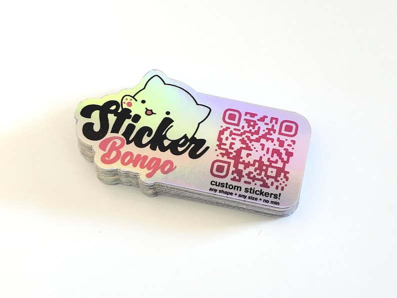May include: A stack of iridescent holographic stickers with the text "Sticker Bongo" and a cartoon cat. The stickers also feature a QR code and the text "custom stickers! any shape - any size - no min".