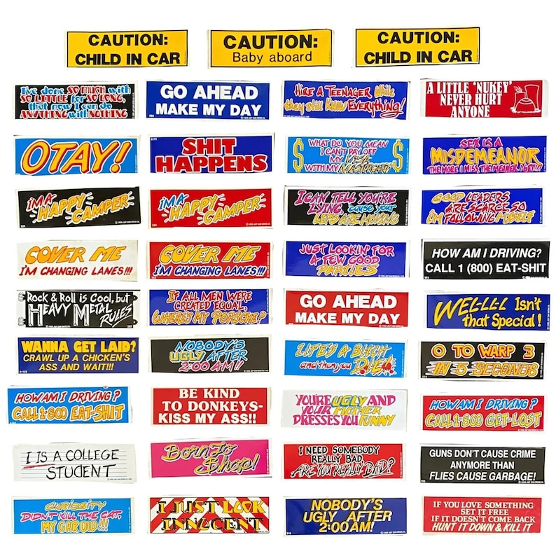 May include: A collection of rectangular bumper stickers featuring various humorous and sarcastic phrases in bold, colorful typography. The stickers include slogans like 'Caution: Child in Car', 'Shit Happens', 'Go Ahead Make My Day', and 'How Am I Driving? Call 1-800 Eat-Shit' printed on white, blue, red, and black backgrounds.