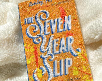 A book covered in rhinestones and diamonds - The Seven Year Slip by Ashley Poston