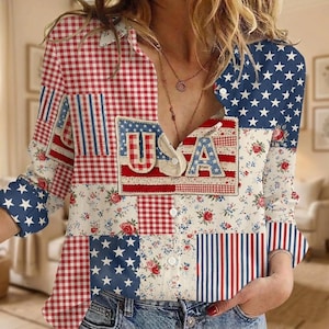 Puede incluir: Una camisa patchwork con un diseño patriótico en rojo, blanco y azul. La camisa combina telas de cuadros, florales y con estrellas, con "USA" aplicado en la parte delantera. Las mangas y los paneles frontales muestran el diseño de la bandera estadounidense.