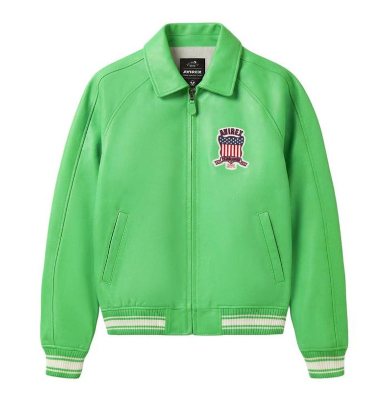 Puede incluir: Chaqueta de cuero verde brillante con cremallera, cuello y pu&ntilde;os y dobladillo acanalados con rayas blancas. Cuenta con un parche con un dise&ntilde;o rojo, blanco y azul y el nombre de la marca. Un estilo bomber cl&aacute;sico.