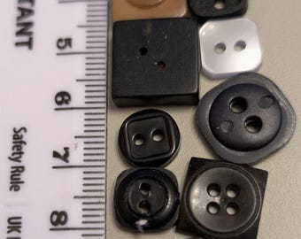 17 blandade fyrkantiga knappar, mestadels svarta