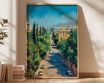 May include: An oil painting depicting a city street scene, framed in light wood. The artwork shows a tree-lined road with yellow cars, buildings, and a mountain range in the background. The sky is a bright blue.
