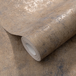 May include: A roll of textured wallpaper in shades of brown, gold, and blue. The paper has a distressed, metallic finish, with areas of lighter gold and darker blue-brown tones. The roll is partially unrolled, revealing the paper's edge.