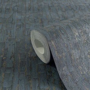 May include: A roll of textured wallpaper in shades of blue and gold. The wallpaper has a brick-like pattern with a rough, uneven surface. The roll is partially unrolled, revealing the paper's interior. The overall aesthetic is rustic and industrial.