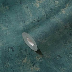 May include: A roll of teal-colored wallpaper with a textured, mottled appearance. The design incorporates shades of teal, dark blue, and gold, creating a rustic, aged aesthetic. The roll is partially unrolled, revealing the white core.