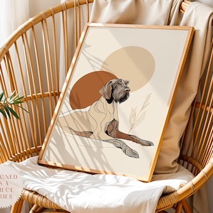 Puede incluir: Una impresión artística enmarcada con un dibujo lineal de un perro en tonos marrones y beige, sobre un fondo marrón y beige. La obra de arte se exhibe en una silla de mimbre. El texto "DESIGNED AS A 3 PIECE SERIES" es visible.