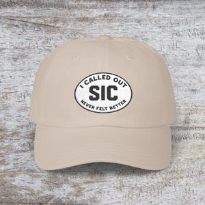 Puede incluir: Gorra de béisbol beige con visera curva. La gorra presenta un parche bordado con el texto "I CALLED OUT SIC NEVER FELT BETTER" en blanco y negro. El sombrero está hecho de un material suave y tiene una correa ajustable.