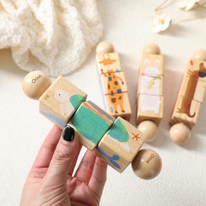 May include: Wooden toy featuring animal illustrations and the name "Chloe". The toy has a turtle, giraffe, rabbit, and dachshund design. The blocks are connected with wooden beads. The toy is designed for children.