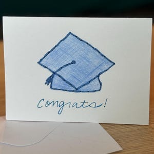 Félicitations ! Carte de remise des diplômes - dessinée à la main avec une casquette de diplômé bleue et un contour de casquette brodé (4 x 6)