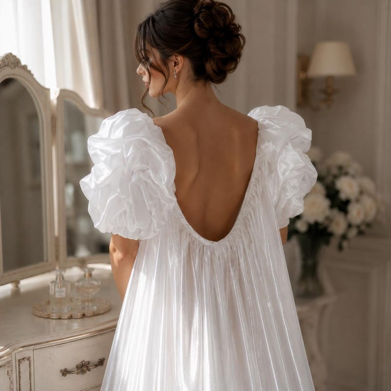 Elegant floor-length bridal robe with dramatic puff sleeves crafted from lightweight sheer fabric. Romantic wedding robe available in white and champagne, perfect for bridal getting ready photos, honeymoon, bridal boudoir, and luxury wedding morning styling.