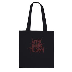 May include: Black tote bag with the text "AFTER HOURS TIL DAWN" in red. The text is stylized with sharp, pointed edges. The bag has two black handles and is made of a solid black material.