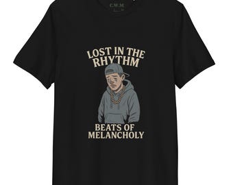 May include: Black t-shirt with a graphic of a person in a hoodie and cap, and the text "LOST IN THE RHYTHM" above and "BEATS OF MELANCHOLY" below. The shirt has a crew neck and short sleeves.