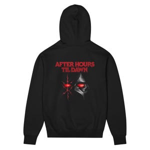 May include: A black hooded sweatshirt featuring the red text AFTER HOURS TIL DAWN printed on the back. Below the text is a graphic design showing a stylized red eye and a metallic mask element with a glowing red eye on a black background.