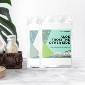 May include: A set of three ceramic mugs with a speckled, cream-colored glaze. Each mug features a different hand-painted design: a blue and green leaf, a yellow flower, and a red berry. The mugs have a simple, modern design.