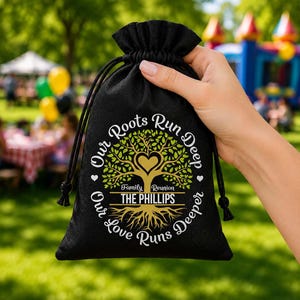 May include: Black drawstring bag with the text "Our Roots Run Deep, Our Love Runs Deeper" surrounding a tree graphic with a heart and the words "Family Reunion THE PHILLIPS". The bag is held by a hand.