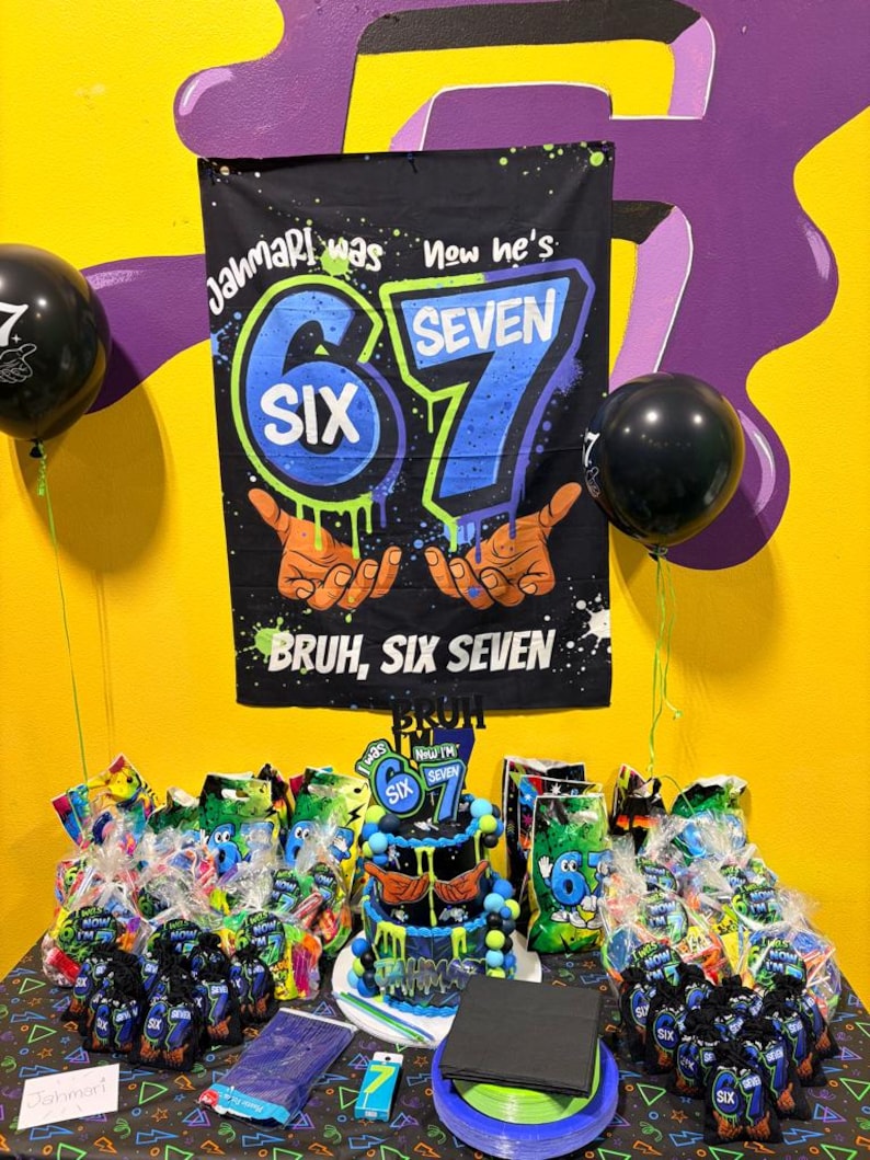 May include: A black birthday banner with blue and green graffiti-style text reading Jahmari was six now he's seven, featuring illustrations of hands and the text Bruh, six seven. Below is a tiered cake, party favor bags, and stacks of plates.