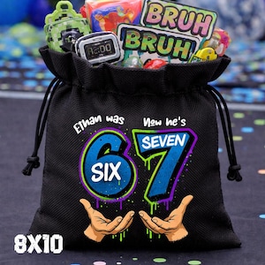 May include: A black drawstring gift bag featuring the text Ethan was SIX, Now he's SEVEN, with a large 6 and 7 graphic, two hands, and the text 8X10. The bag is filled with various small toys, including a digital watch and a BRUH sticker.