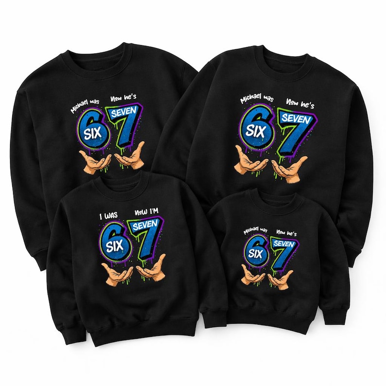May include: Black sweatshirts with a birthday theme. Each sweatshirt features the text "Michael was SIX, Now he's SEVEN" or "I WAS SIX, Now I'M SEVEN" in blue and green, with hands holding the numbers.