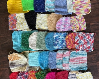 Può includere: Una collezione di spugne abrasive all'uncinetto, quadrate e rettangolari, in una varietà di colori e consistenze. Le spugne presentano motivi in filato a tinta unita, variegato e maculato nei toni del giallo, verde, blu, rosa, rosso, nero e bianco.