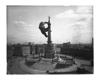 Puede incluir: Una fotografía en blanco y negro de un gran simio escalando un monumento en una plaza de la ciudad. El simio está escalando el Monumento a los Soldados y Marineros en Indianápolis, Indiana.