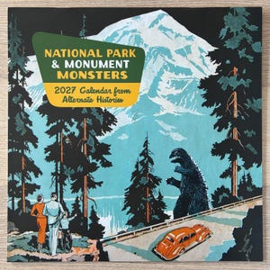 May include: A 2027 calendar titled National Park & Monument Monsters from Alternate Histories featuring a retro illustration of a large monster, a vintage orange car, and three people standing before a snow-capped mountain and forest.