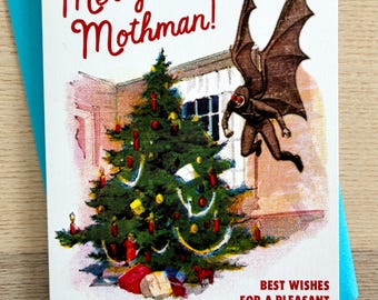 May include: A Christmas card with a vintage illustration. The card features a decorated Christmas tree, a flying Mothman figure, and the text "Merry Mothman!" in red. The card is on a blue envelope and reads "Best Wishes for a Pleasant Holiday Season."