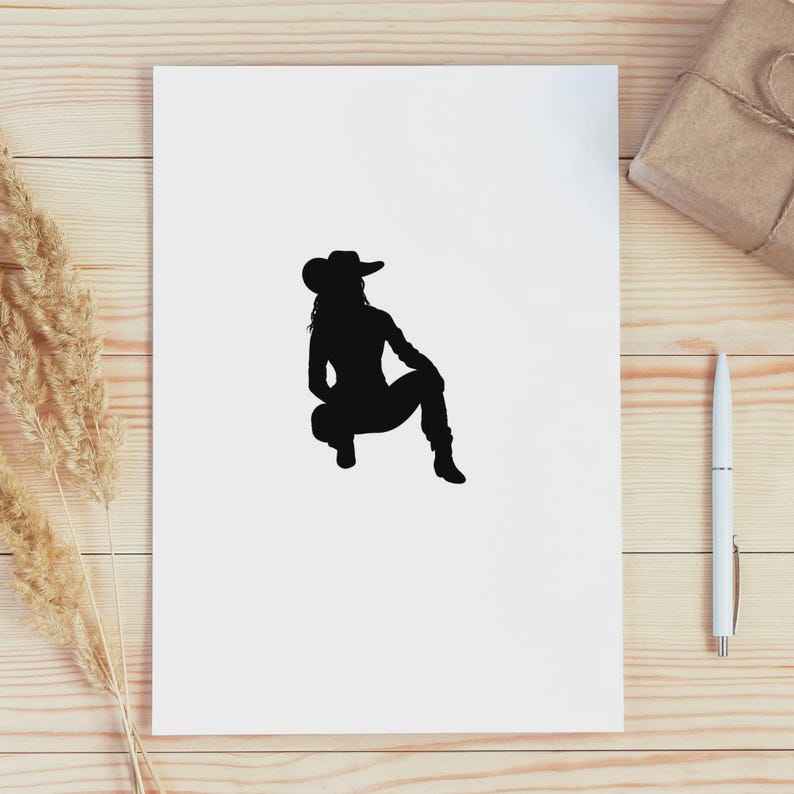 May include: A black silhouette of a person wearing a cowboy hat, boots, and jeans, in a squatting position. The image is on a white background, with a pen, a wrapped gift, and dried plants in the background.