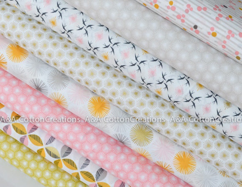 May include: A stack of eight fabric squares with different geometric patterns in shades of white, pink, yellow, and gray. The patterns include small circles, stars, and birds.