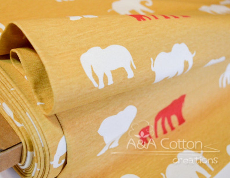 May include: A close-up of a yellow fabric with a white elephant print. The fabric is folded and the print is visible on both sides. The fabric is labeled "A&A Cotton creations".