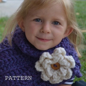 Könnte beinhalten: Ein junges Mädchen trägt einen lilafarbenen Häkelkragen mit einem weißen Häkelblumen-Akzent. Die Blume hat einen braunen Knopf in der Mitte. Der Text "PATTERN" ist in der linken unteren Ecke des Bildes sichtbar.