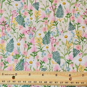 K&ouml;nnte beinhalten: Ein rosa-wei&szlig;er Stoff mit einem sich wiederholenden Muster aus gr&uuml;nen Farnen, rosa Bl&uuml;ten und gelben Wildblumen. Ein Lineal ist zur Gr&ouml;&szlig;enbestimmung im Bild enthalten.