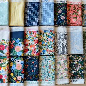 May include: A collection of 18 fabric swatches featuring floral, geometric, and animal print designs. The fabrics are in various colors, including blue, green, pink, and white. The fabric swatches are arranged in three rows of six.