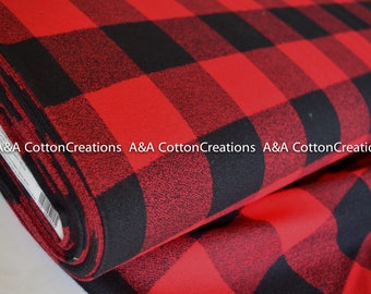 May include: Red and black buffalo plaid fabric. The fabric is folded and shows the texture of the material.