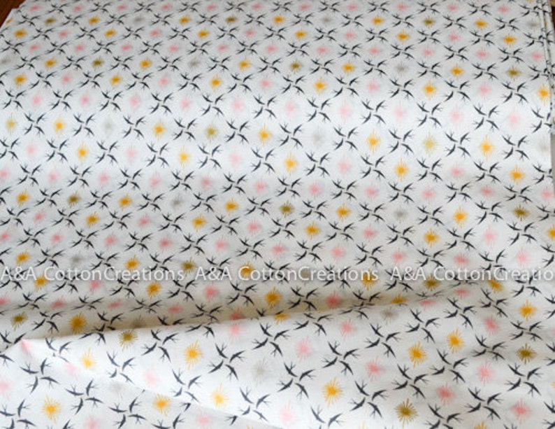 May include: White cotton fabric with a repeating pattern of black birds, pink and yellow stars.  A&A Cotton Creations is printed on the fabric.