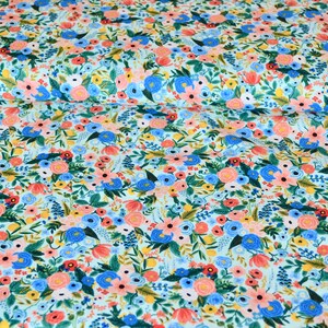 Puede incluir: Una tela azul claro con un patr&oacute;n floral con flores rosas, azules, amarillas y verdes. La tela est&aacute; cubierta con un patr&oacute;n denso de flores.