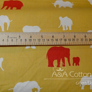 May include: A yellow fabric with a repeating pattern of white and red elephants. The elephants are in various sizes and positions. A ruler is placed on the fabric for scale. The text "A&A Cotton creations" is printed on the fabric.