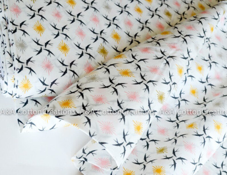 May include: White cotton fabric with a repeating pattern of black birds flying in a diagonal direction. The background has a repeating pattern of yellow and pink stars.