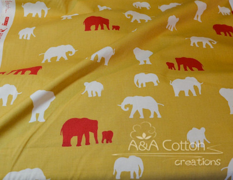 May include: Yellow fabric with a repeating pattern of white and red elephants. The elephants are in various sizes and positions. The fabric has the text "A&A Cotton creations" printed on it.