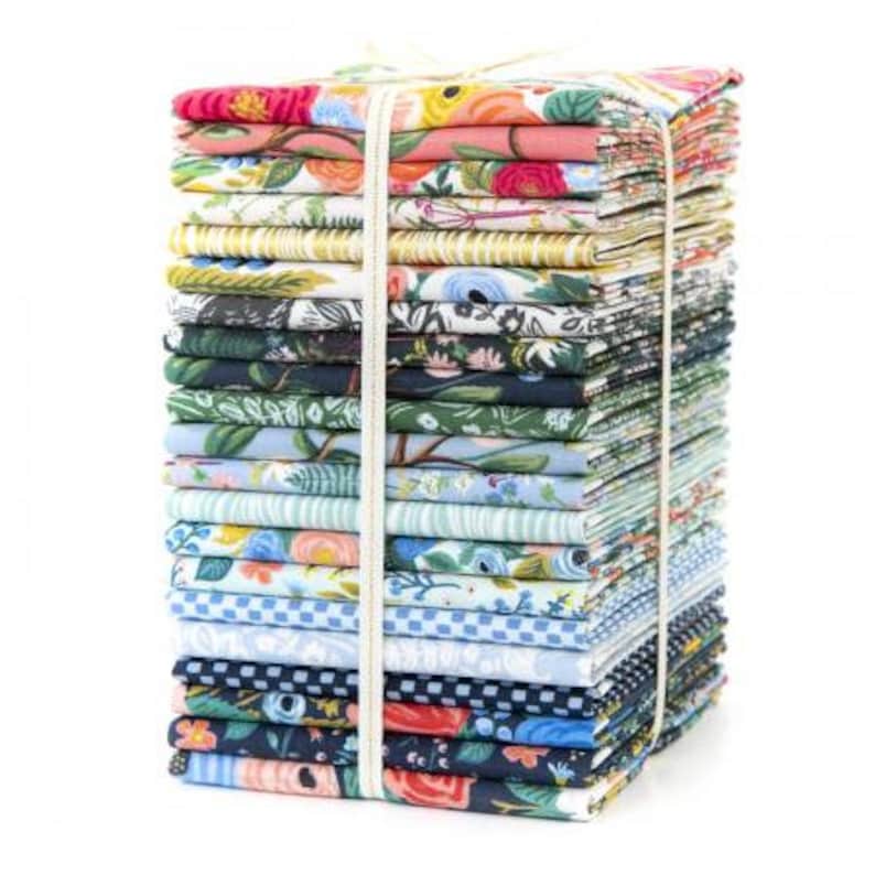 May include: A stack of 24 fat quarters of fabric featuring a variety of floral patterns in shades of blue, green, pink, and yellow. The fabric is tied together with a white ribbon.